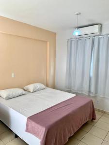 1 dormitorio con 1 cama grande y ventana en Flats em Goiania, en Goiânia