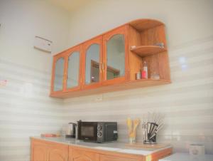 cocina con encimera y microondas en Success Apartments-Gold, en Mwanza