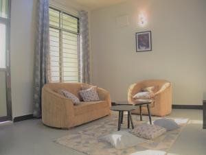 a living room with two chairs and a table at Success Apartments-Gold in Mwanza