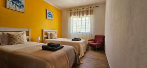 una camera d'albergo con due letti e una finestra di Apartamento - Férias Felizes Portimão a Portimão