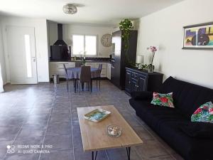 een woonkamer met een bank en een tafel bij La Villa d'A-Mours in Mours-Saint-EusÃ¨be