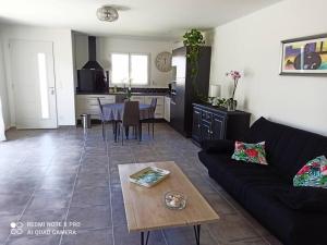 a living room with a couch and a table at La Villa d'A-Mours in Mours-Saint-EusÃ¨be