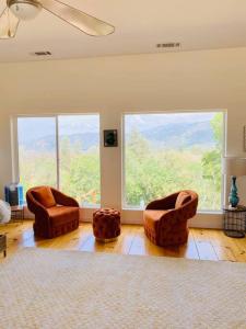 a living room with two chairs and a large window at Modern House on 5 acr in Sequoia National Forest in Panorama Heights