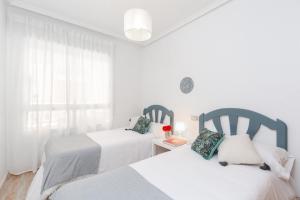 biała sypialnia z dwoma łóżkami i oknem w obiekcie Delightful Retreat by Fidalsa w mieście El Moncayo