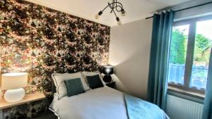 1 dormitorio con una pared de flores y 1 cama en Apartament Pod Czereśnią, en Suwałki