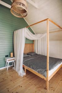 a bedroom with a bed with a canopy at Morze2 - domy całoroczne nad morzem in Lubiatowo