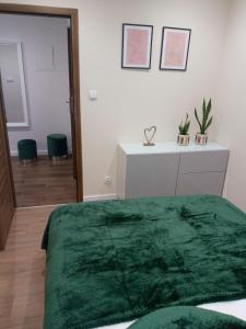 a bedroom with a green blanket on a bed at Zielony Zakątek in Sandomierz