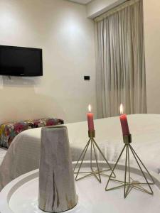 two candles on a table in front of a bed at Luxury apartment in Fez