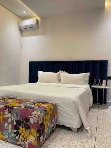 una camera con un grande letto con testiera blu di Luxury apartment a Fes