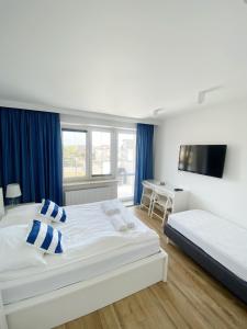 a bedroom with two beds and a flat screen tv at Willa Balticana in Władysławowo