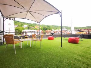 een patio met een tafel en stoelen en een parasol bij Donath Loft in Cluj-Napoca