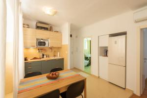 Pula City Apartment with private parking FREE في بولا: مطبخ وغرفة طعام مع طاولة وكراسي