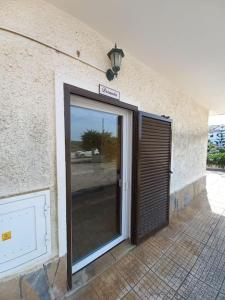 a door with a sign on the side of a building at Casa do Portão Azul - Dourada in Atouguia da Baleia