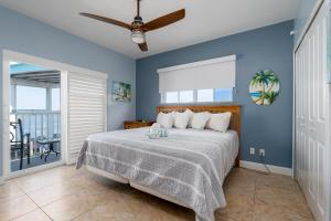 a bedroom with a bed with a blue wall at Best View and rooms of Harbour House at the INN in Fort Myers Beach