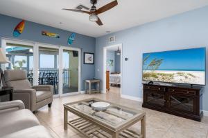 a living room with a couch and a tv at Best View and rooms of Harbour House at the INN in Fort Myers Beach