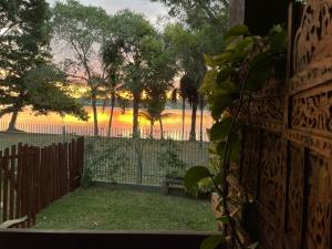 a view of a fence with a sunset in the background at Casa do Lago Hospedaria in Brasília