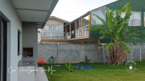 una casa con una palmera en el patio en Casa confortável com 2 quartos e 1 suíte, pertinho do Mar, Praia Grande - Beto Carrero, Penha SC, en Penha