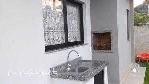 cocina con fregadero y ventana en Casa confortável com 2 quartos e 1 suíte, pertinho do Mar, Praia Grande - Beto Carrero, Penha SC, en Penha