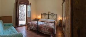 ein Schlafzimmer mit einem Bett und einem Stuhl und einem Fenster in der Unterkunft Biologico Dell'Etna in Trecastagni