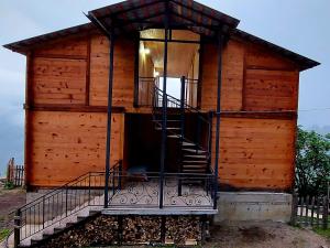 ein kleines Holzgebäude mit einer Treppe in der Unterkunft Wooden House Garetke in Batumi