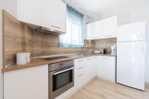 a kitchen with white cabinets and stainless steel appliances at Anesis Seaview Apartment 2 in Neos Marmaras