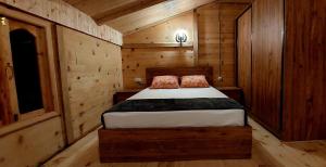 Wooden House Garetke في باتومي: غرفة نوم بسرير في كابينة خشبية