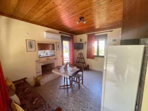 uma sala de estar com uma mesa e um frigorífico em Miro & Lana vacation home em Kinira