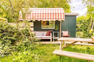 um pequeno barracão com um banco e uma mesa em Tiny House em Kampen