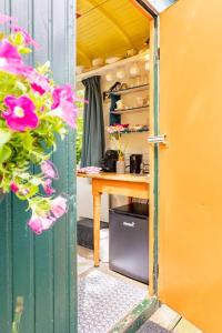 uma porta aberta para um quarto com uma mesa e flores em Tiny House em Kampen