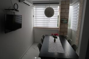 a dining room table with chairs and a vase of flowers at Apartment Samanta in Supetar