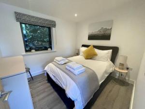 een slaapkamer met een bed met handdoeken erop bij "Brett" Scandinavian Lodge with private hot tub in East Bergholt