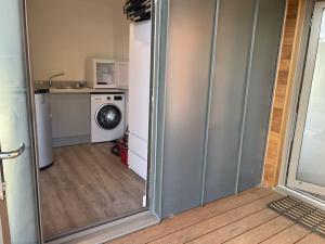 a room with a mirror and a kitchen with a washing machine at "Brett" Scandinavian Lodge with private hot tub in East Bergholt