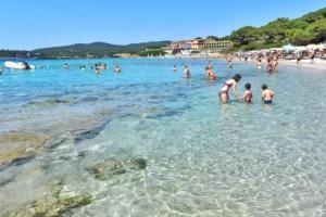 a group of people in the water at a beach at Alghero Sa Stella Casa Vacanze in Fertilia