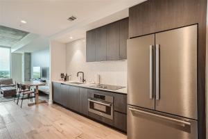 a kitchen with a stainless steel refrigerator and a table at Spacious 1 BR condo - Amazing views - Pool - Kitchen in Austin
