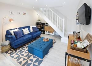 a living room with blue couches and a tv at Castle Hideaway in the Cotswolds in Chipping Campden