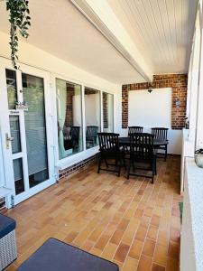 un porche cubierto con mesa y sillas en Strandhaus Graalibu, en Graal-Müritz