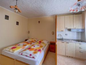 リヴィーニョにあるCasa Letiziaの小さなベッドルーム(ベッド1台付)、キッチンが備わります。