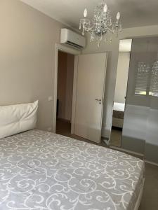 - une chambre avec un lit et un lustre dans l'établissement Maison Chic Montenero Marina, à Marina di Montenero