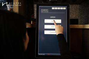 una persona apuntando a la pantalla de una tablet en Hotel Initial-Beer en Tainan