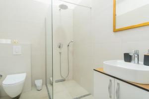 a white bathroom with a sink and a shower at Stan lux Kašmir in Bugojno