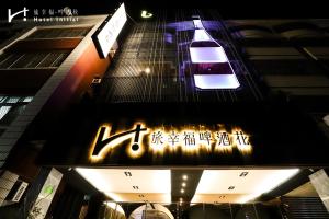 a sign on the side of a building with a car at Hotel Initial-Beer in Tainan