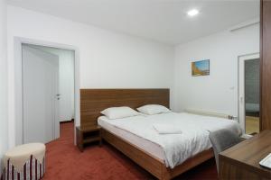 um quarto com uma cama grande e uma cabeceira em madeira em Stan lux Kašmir em Bugojno