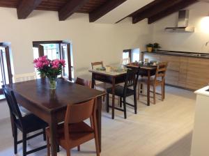 cocina y comedor con mesas y sillas de madera en Al Borgo Affittacamere en Venzone
