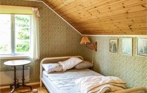 een slaapkamer met een bed en een houten plafond bij 3 Bedroom Nice Home In Norrtlje in Norrtälje