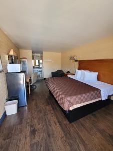 una habitación de hotel con una cama grande en una habitación en Westerner Motel, en Williams