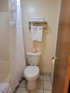 a bathroom with a toilet with towels and a shower at Westerner Motel in Williams