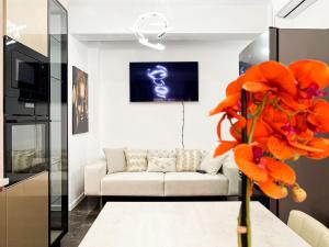 un soggiorno con divano bianco e fiori arancioni di Residence Future Delux IV a Giroc
