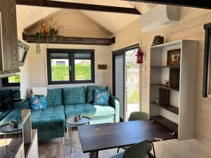 a living room with a couch and a table at Tiny House Lovely Sunshine in Giethoorn