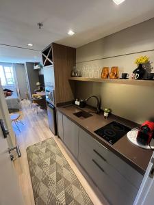 a kitchen with a sink and a stove in a room at Studio luxo Granja Brasil Green Mountain flat - Itaipava in Itaipava