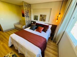 a bedroom with a large bed and a window at Studio luxo Granja Brasil Green Mountain flat - Itaipava in Itaipava